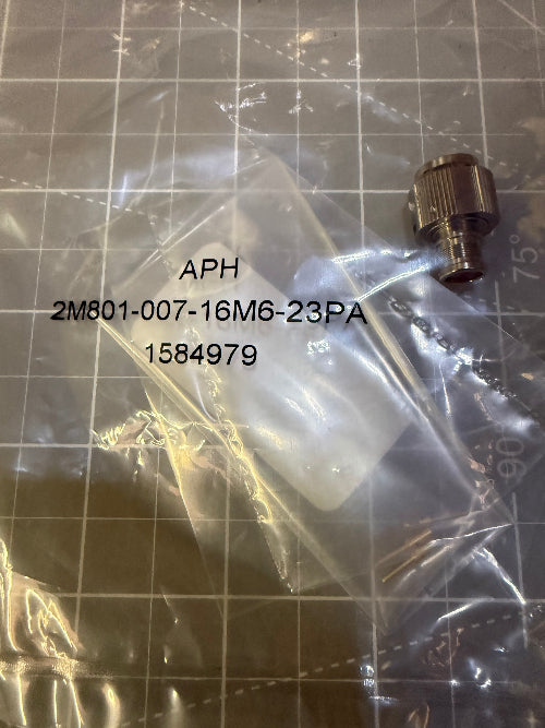 A small metal connector fitting in a clear plastic bag with printed part number text, placed on a gridded surface.