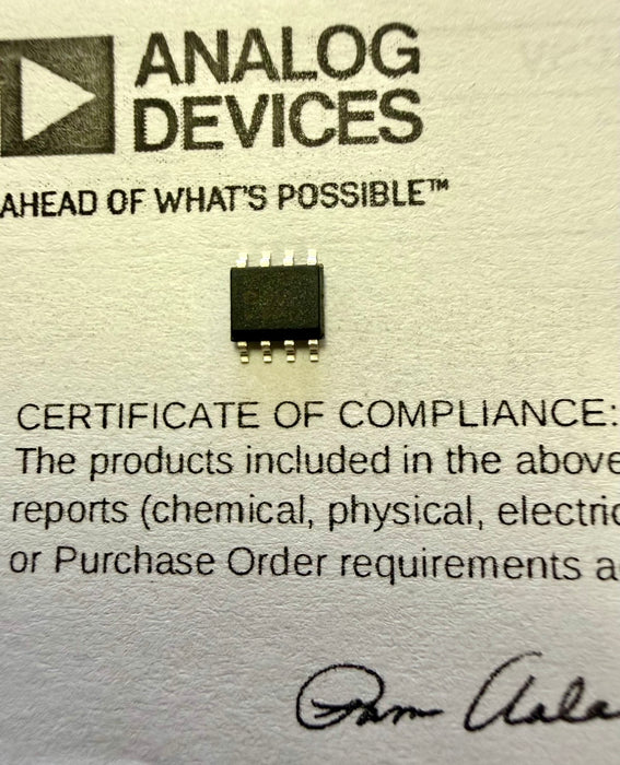 Analog Devices certificate of compliance with a small electronic component on a gray background