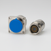 Two connectors, one with a blue light and the other with a metallic finish, on a white background.