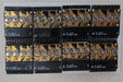 Six black electronic circuit boards with gold traces and silver crystal components, arranged in two rows of three on a light gray textured surface.