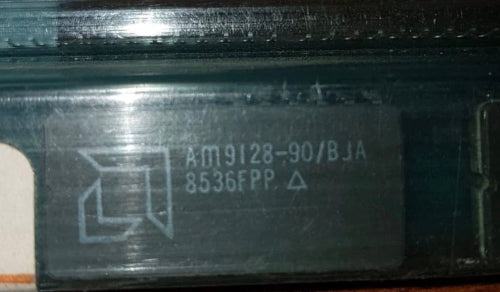 AM9128-90/BJA by AMD Close-up of a electronic component with text and symbols on a metallic surface